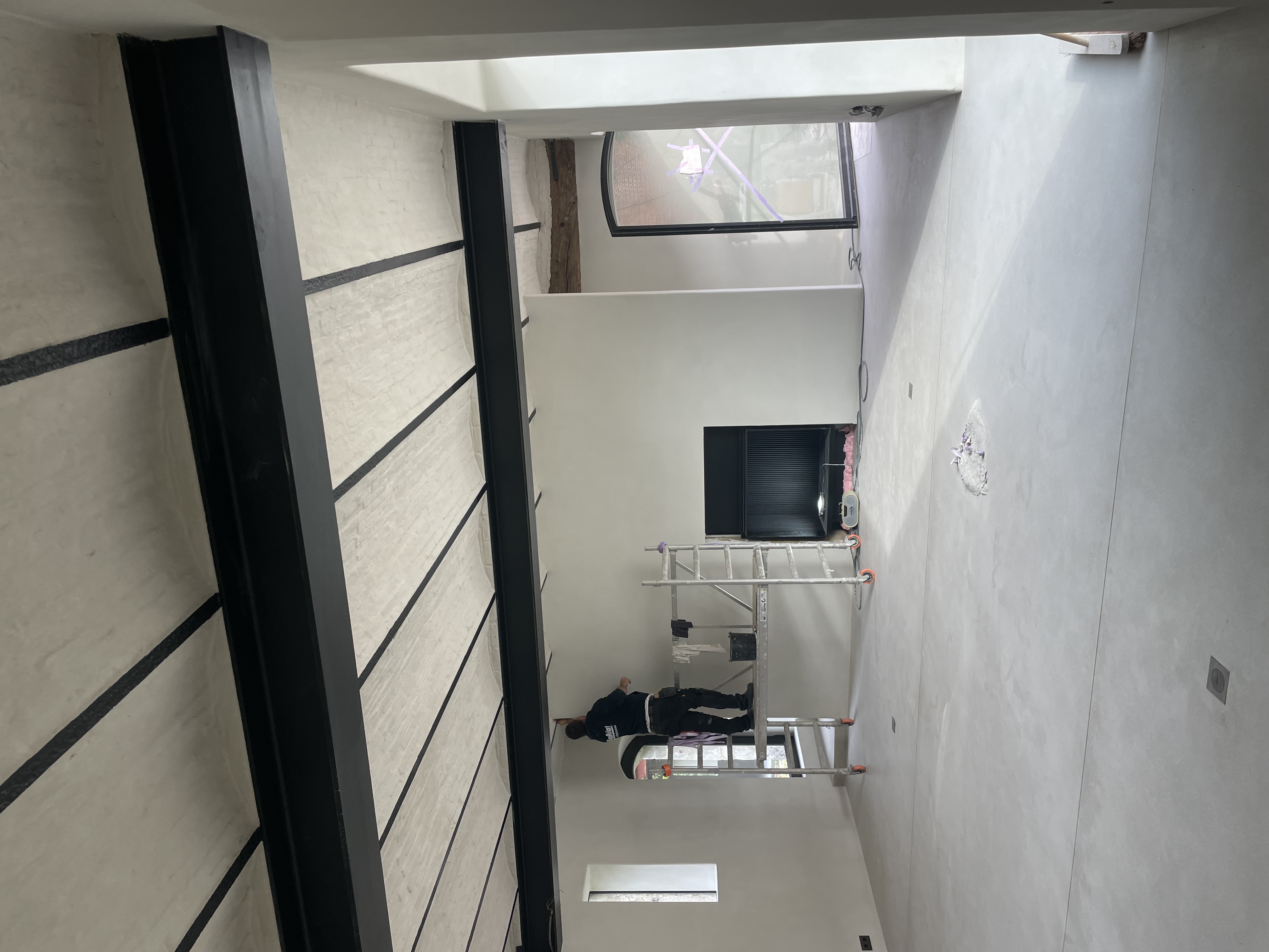 Vakman bezig met pleisterwerken in een woning