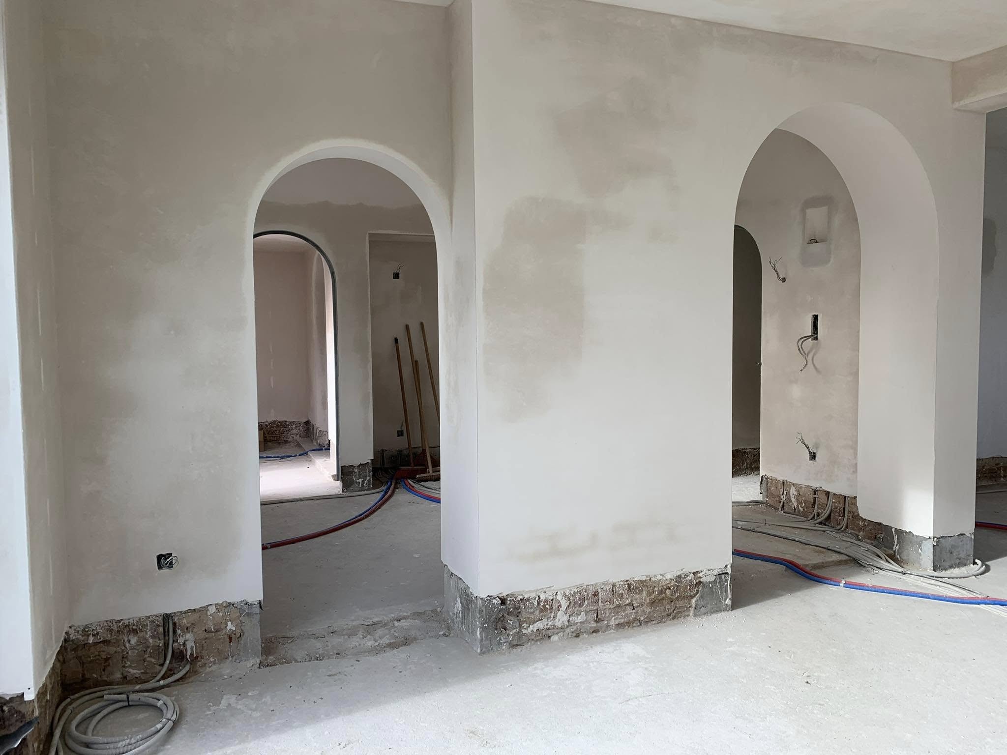 Binnenruimte in afwerking met gepleisterde muren en bogen