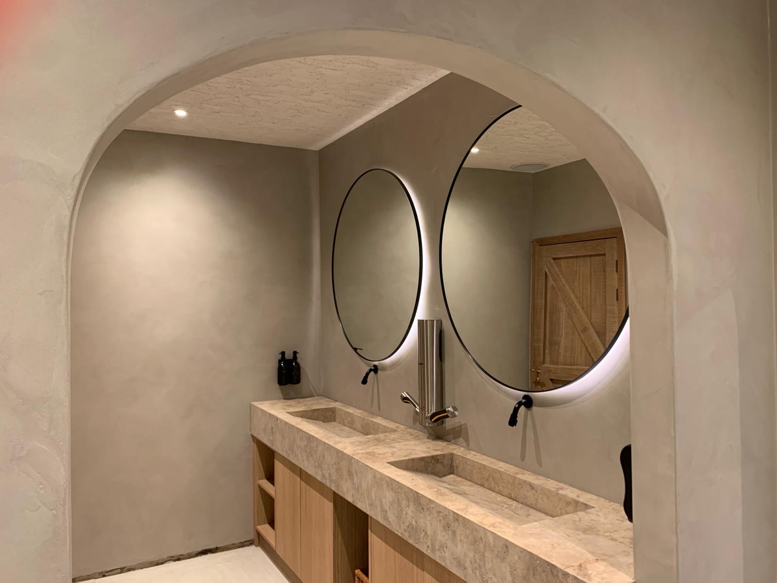 Badkamerhoek met afgeronde doorgang en strak pleisterwerk