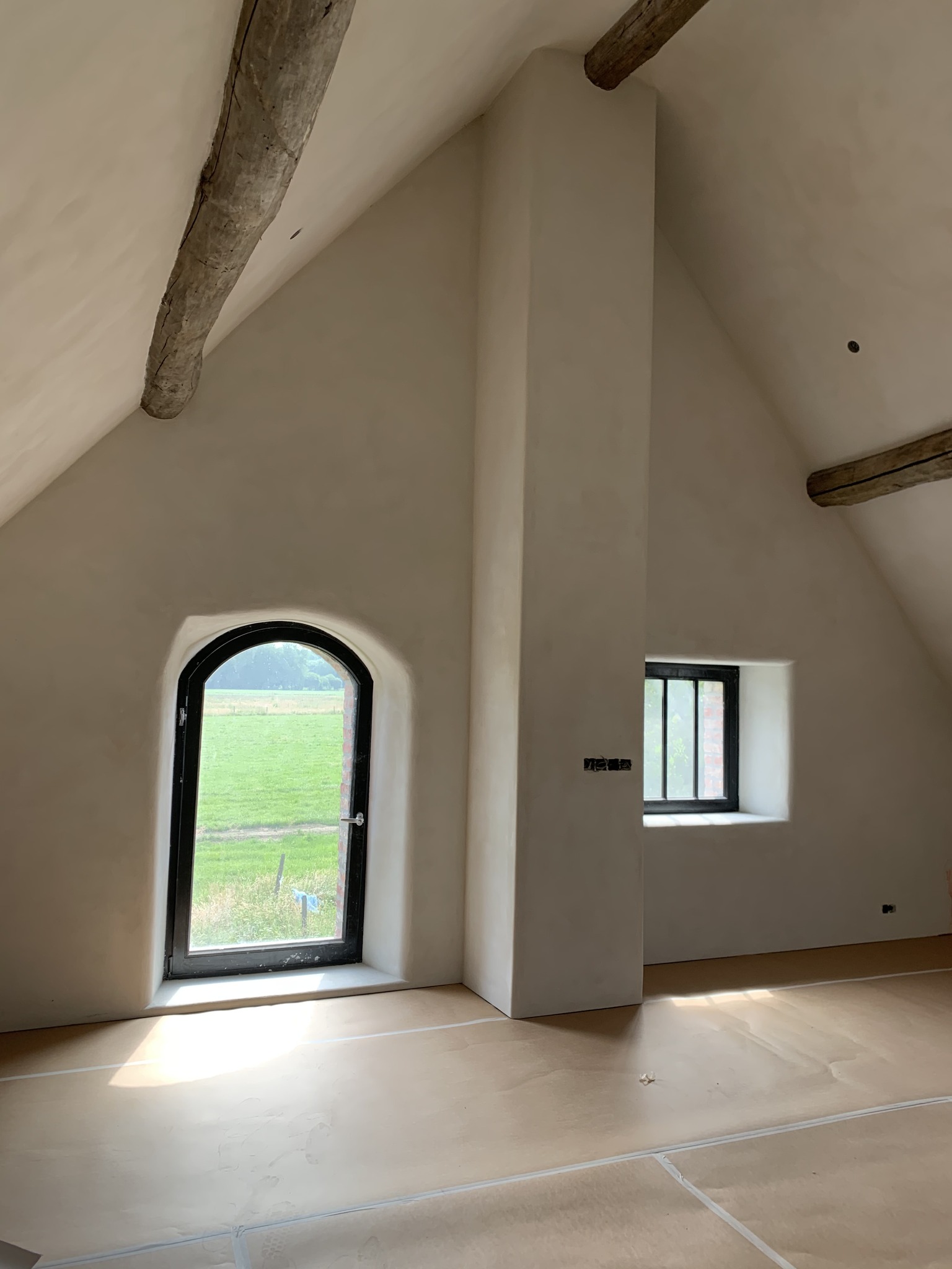 Ruime afgewerkte leefruimte met pleisterwerken